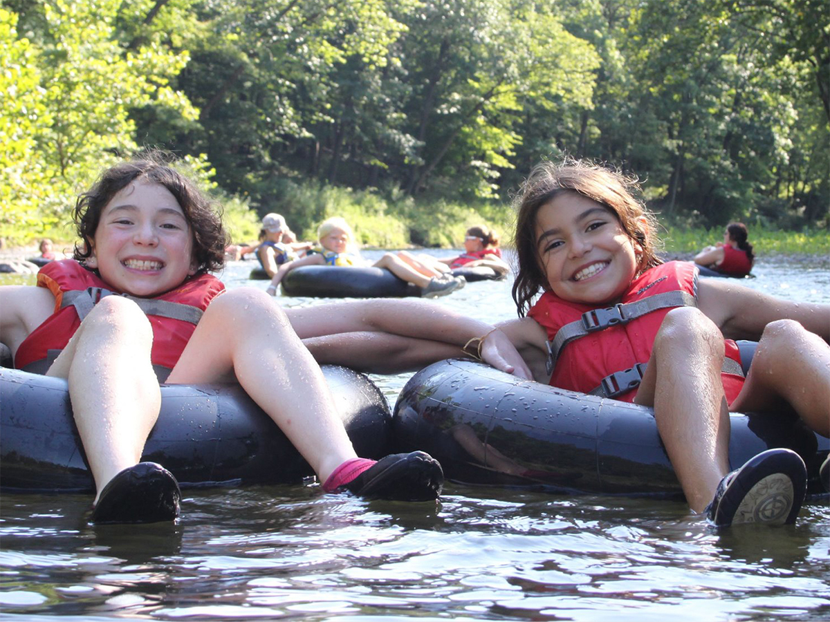 girls rafting down river in innertubes